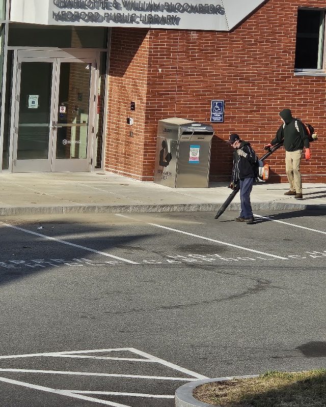 Crew clearing leaves at the Medford Public Library entrance
