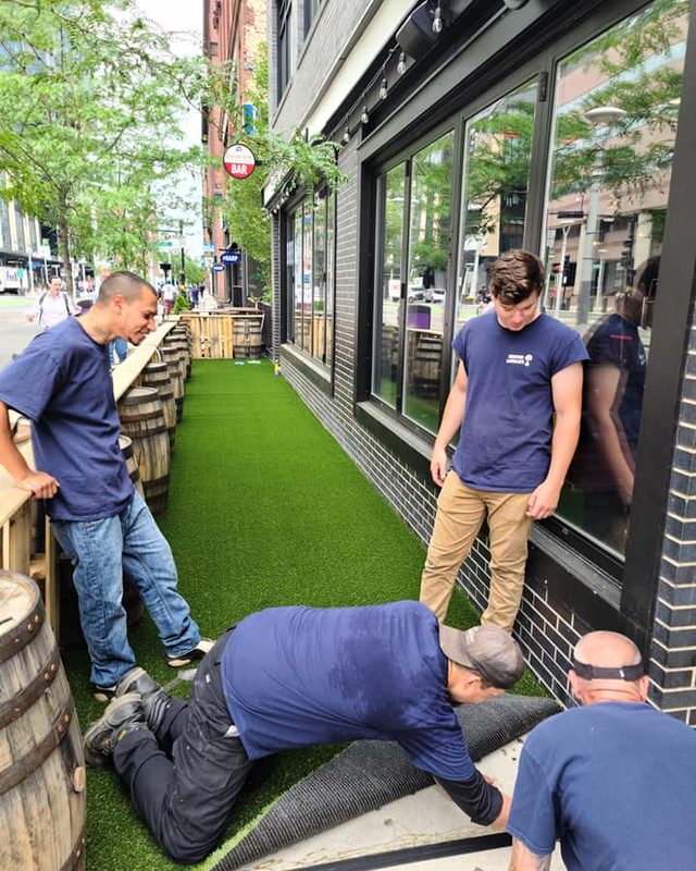 American Elm crew installing synthetic turf on a downtown Boston bar patio